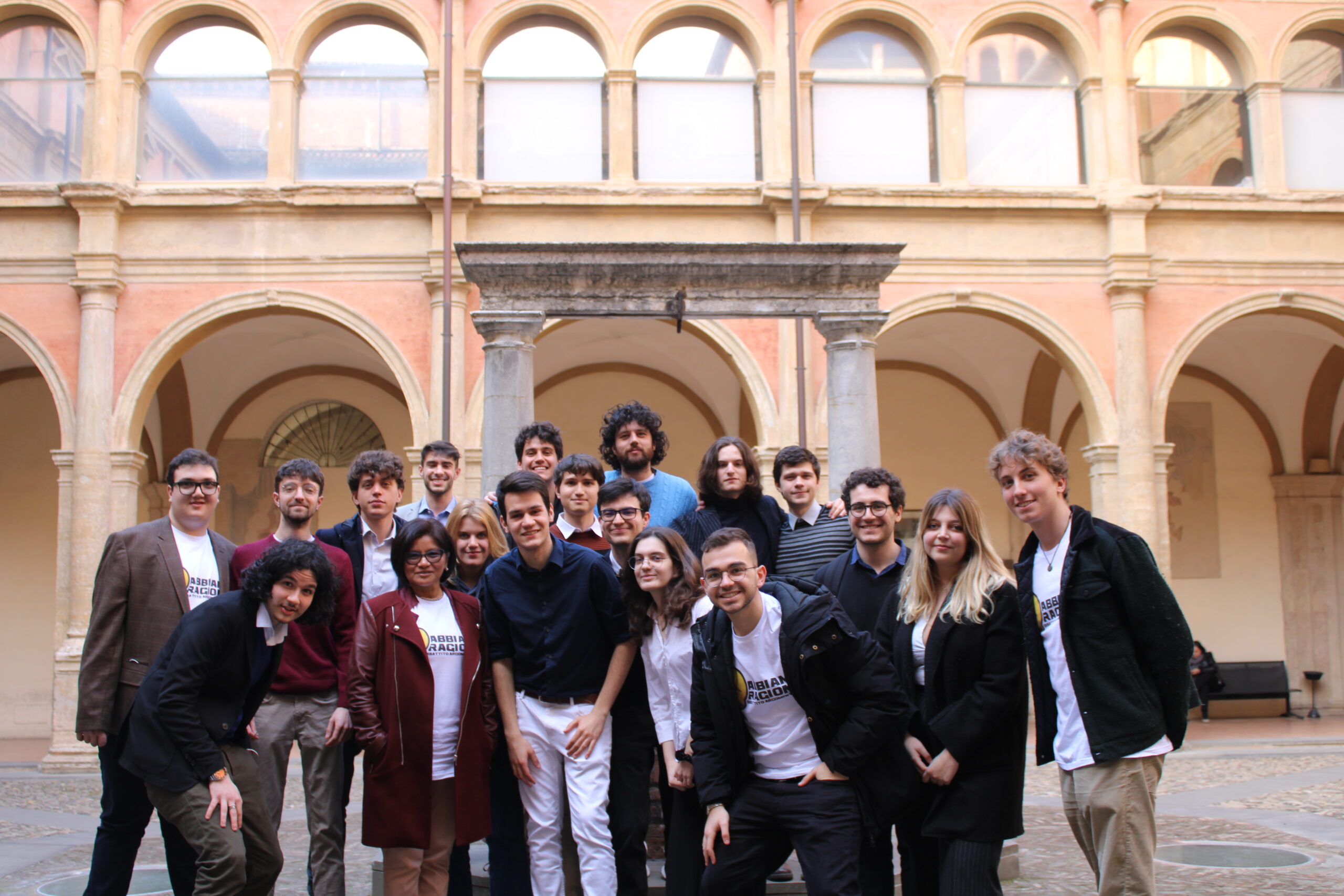 Gruppo di studenti universitari e partecipanti a un progetto di dibattito riuniti in un chiostro universitario